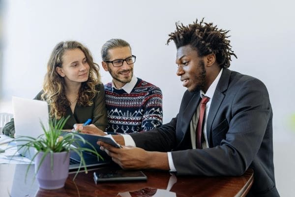 A group of people sitting at a table looking at a document